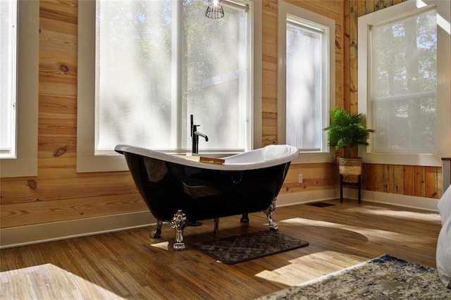 interior space with hardwood / wood-style flooring and wooden walls