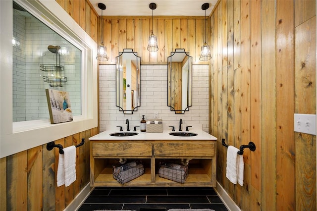 bathroom with tile patterned flooring, vanity, wood walls, and tasteful backsplash