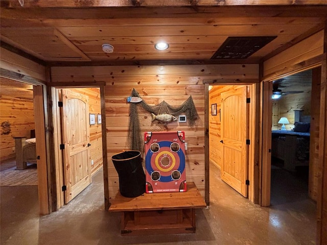 game room with concrete flooring and wooden walls