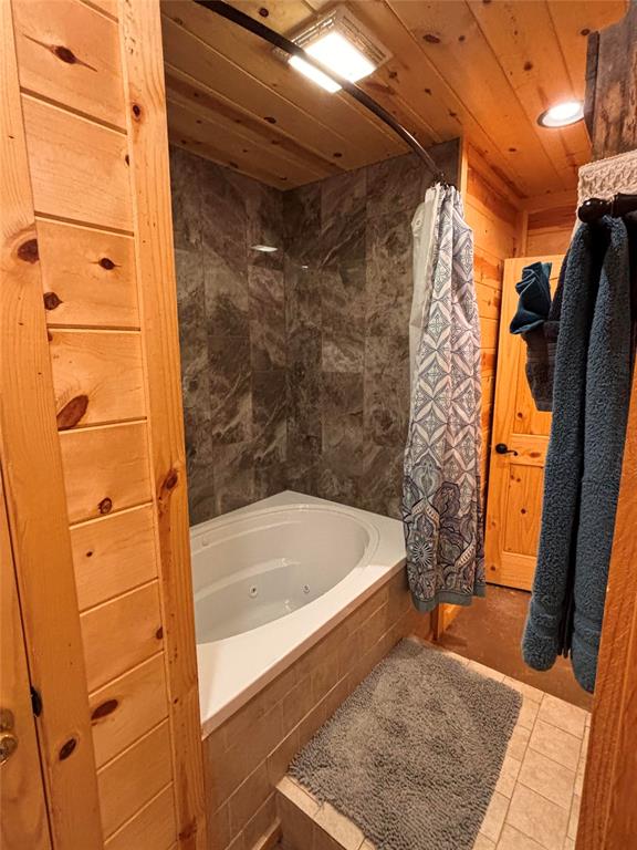 bathroom with tile patterned floors, shower / bath combo, and wooden ceiling