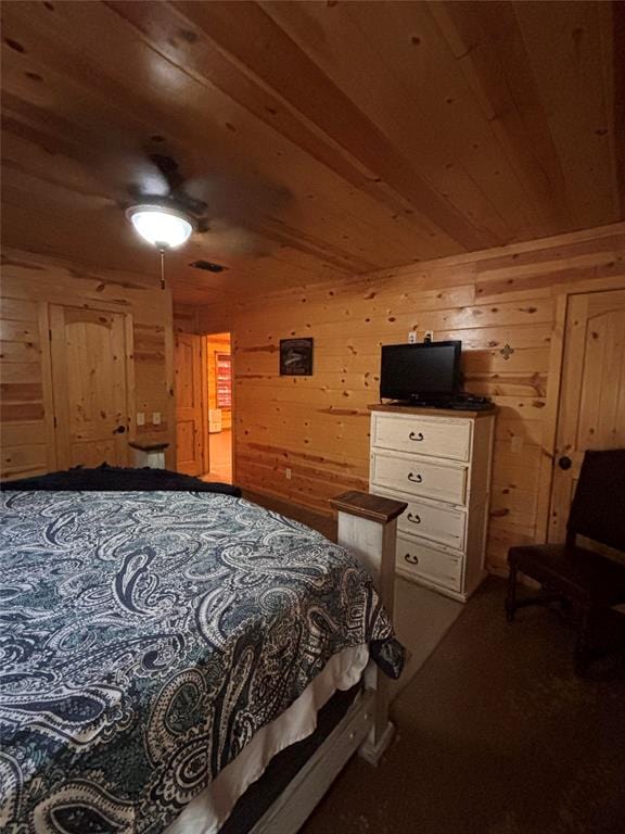 bedroom with ceiling fan, wooden ceiling, and wood walls