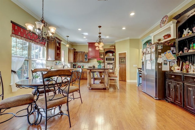 dining area featuring ornamental molding, a chandelier, and light wood-type flooring