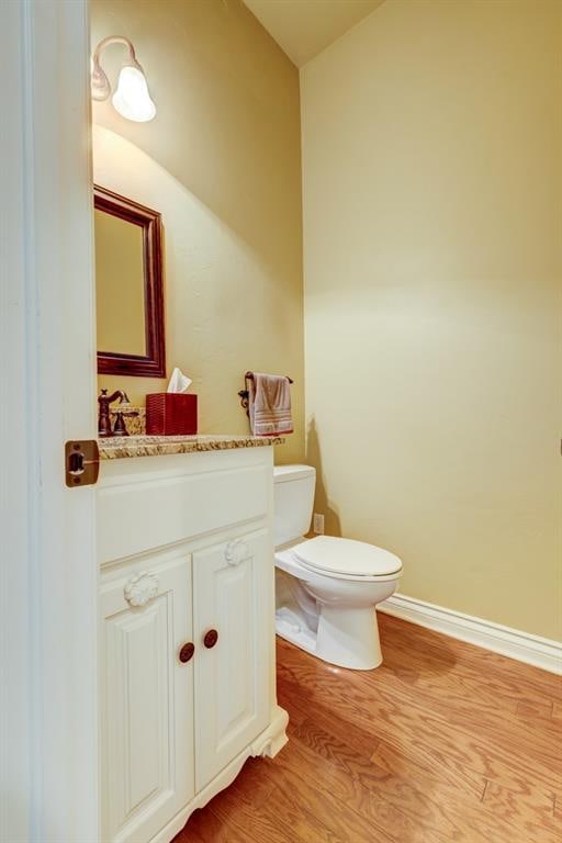 bathroom featuring hardwood / wood-style flooring, vanity, and toilet