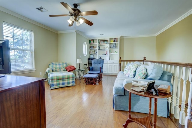 living room featuring light hardwood / wood-style floors, ceiling fan, and ornamental molding