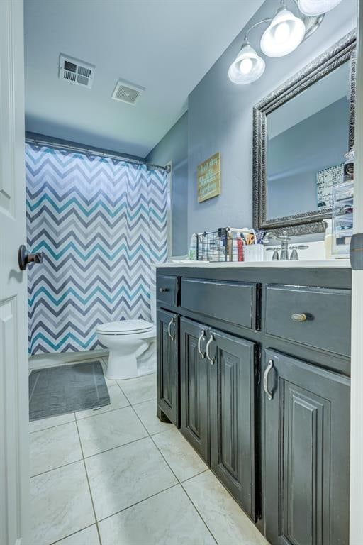 bathroom featuring tile patterned flooring, vanity, and toilet