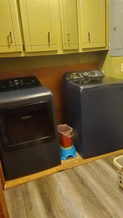 laundry area with hardwood / wood-style floors, washer and dryer, cabinets, and electric panel