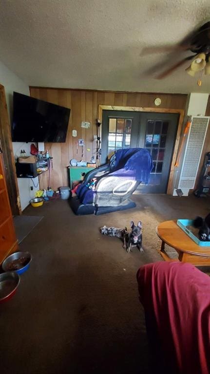 interior space with ceiling fan and wood walls