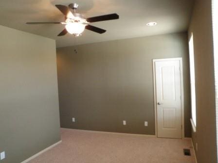 spare room with baseboards, carpet, and ceiling fan