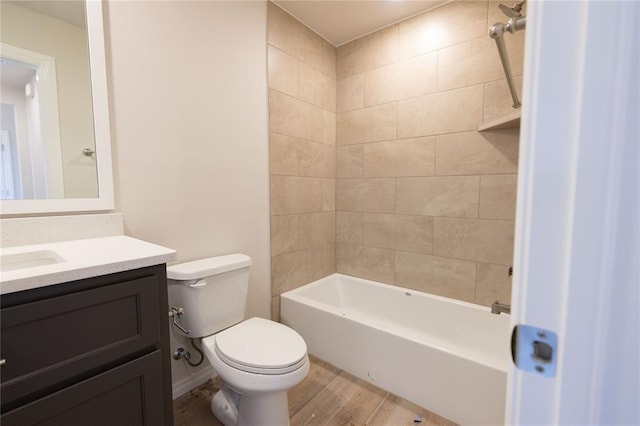 full bathroom featuring tiled shower / bath combo, vanity, hardwood / wood-style floors, and toilet