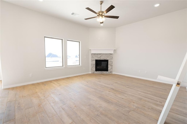 unfurnished living room featuring a fireplace, ceiling fan, and light wood-type flooring