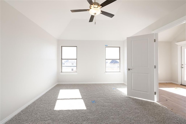 carpeted spare room featuring lofted ceiling and ceiling fan