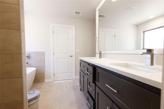 bathroom featuring vanity, tile patterned flooring, and a tub