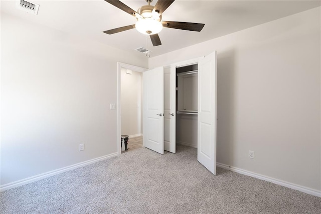 unfurnished bedroom featuring light colored carpet, a closet, and ceiling fan