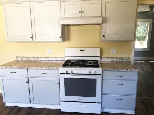 kitchen featuring light stone countertops, gas range gas stove, white cabinetry, and dark wood-type flooring