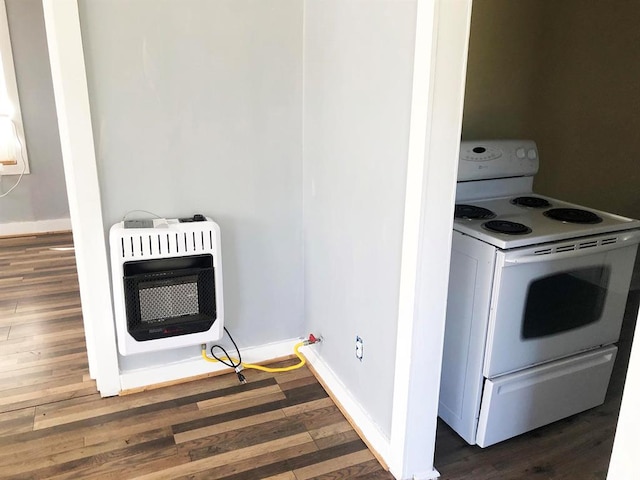 kitchen with dark hardwood / wood-style flooring, white electric stove, and heating unit