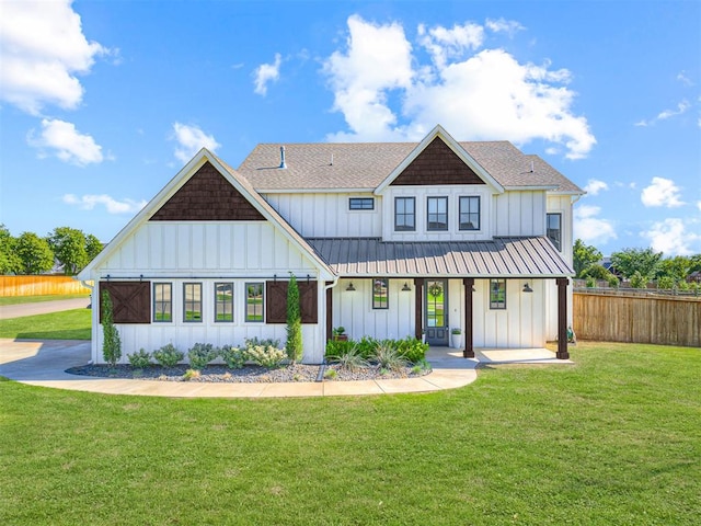 back of house with covered porch and a lawn