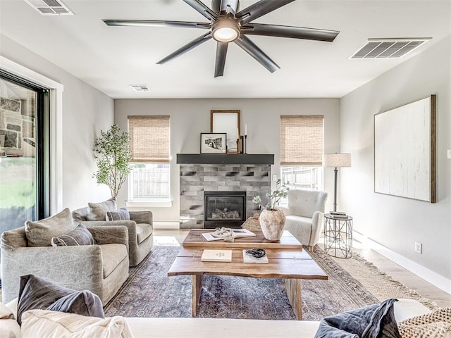 living room with a wealth of natural light, ceiling fan, and wood-type flooring