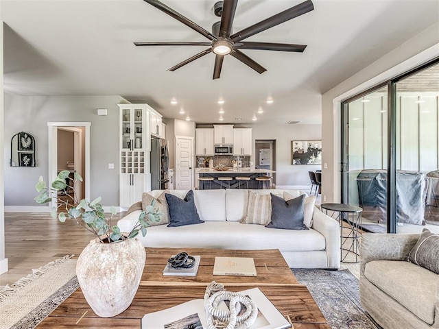 living room featuring ceiling fan and light hardwood / wood-style flooring