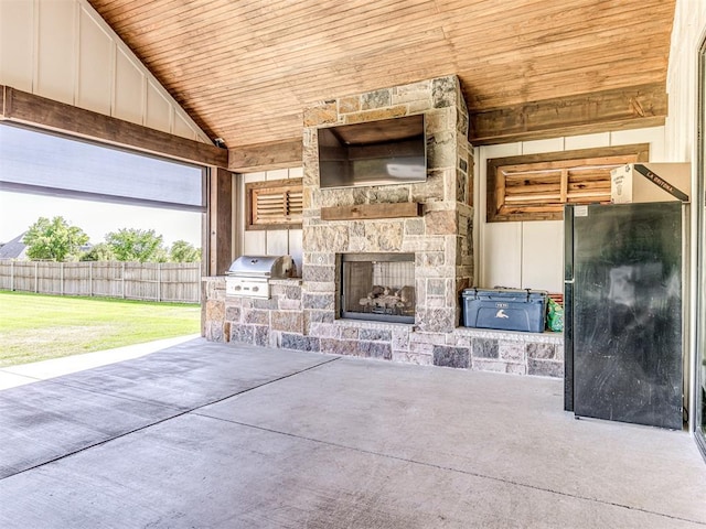 view of patio featuring an outdoor stone fireplace, a grill, and exterior kitchen