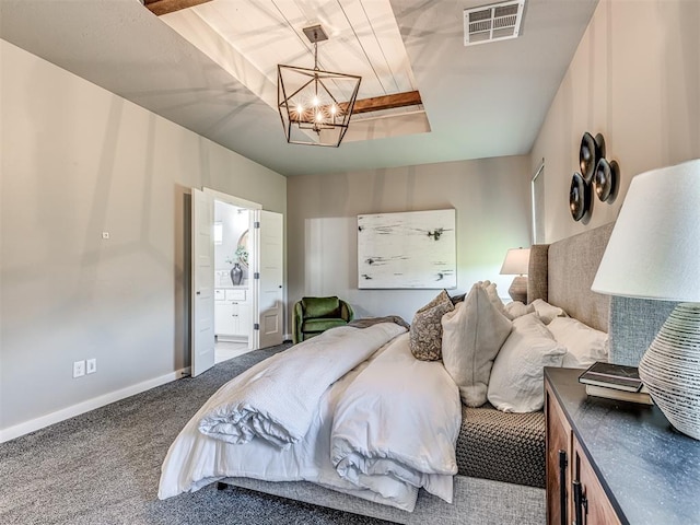 bedroom featuring a chandelier, ensuite bathroom, and dark carpet