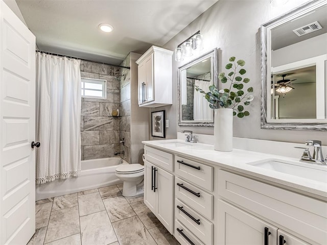 full bathroom featuring ceiling fan, vanity, shower / bath combination with curtain, and toilet