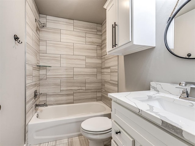 full bathroom with vanity, tiled shower / bath combo, and toilet