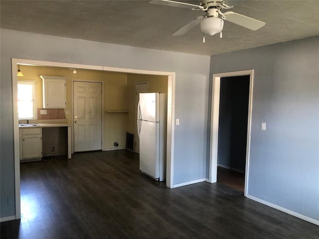 interior space featuring ceiling fan, sink, and dark wood-type flooring