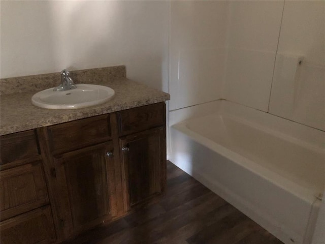 bathroom with hardwood / wood-style floors, vanity, and a bathtub