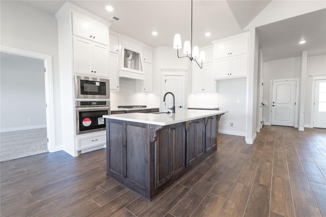 kitchen featuring white cabinets, a center island with sink, and stainless steel appliances