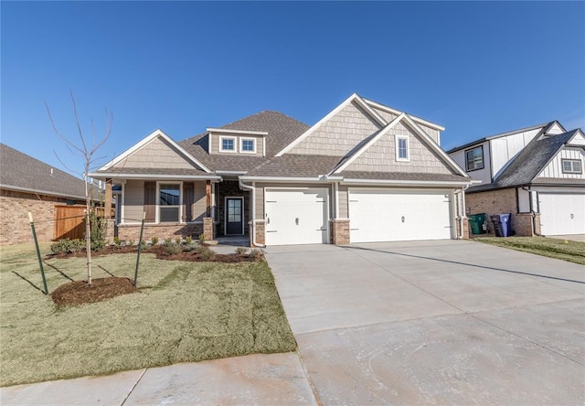 craftsman house with an attached garage, fence, driveway, roof with shingles, and a front lawn