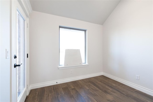 empty room with dark wood-style flooring, vaulted ceiling, and baseboards