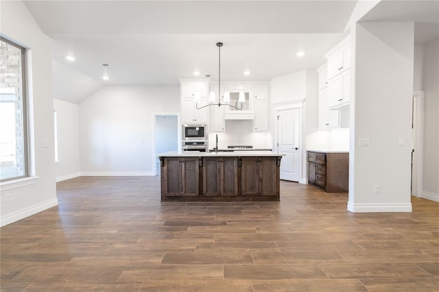 kitchen with white cabinetry, custom exhaust hood, stainless steel oven, and built in microwave