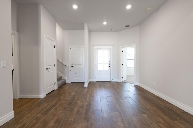 foyer entrance featuring recessed lighting, visible vents, dark wood-type flooring, baseboards, and stairs