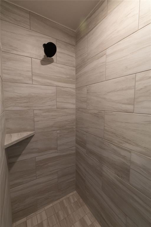 interior details featuring tiled shower