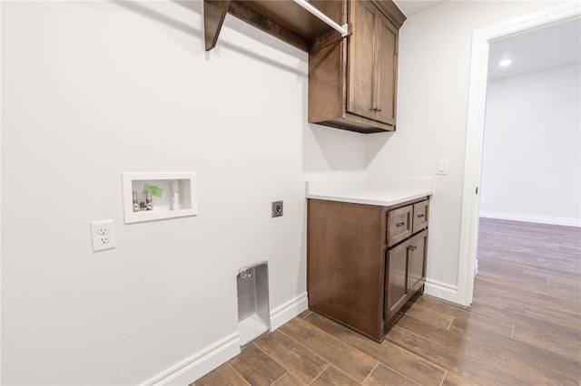 clothes washing area with cabinet space, baseboards, dark wood-style flooring, hookup for an electric dryer, and washer hookup