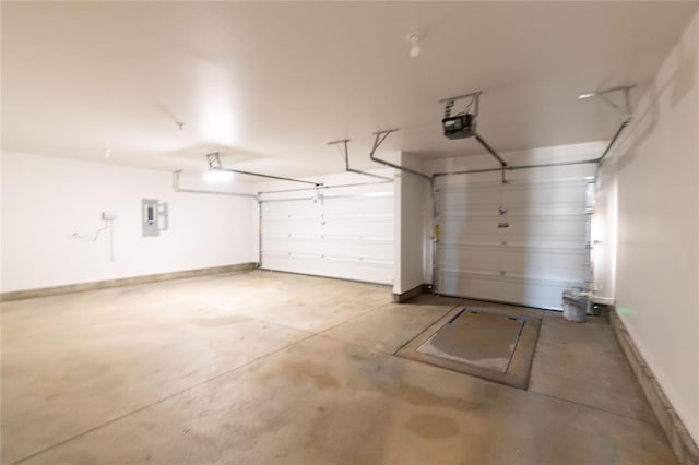 garage with a garage door opener, electric panel, and baseboards