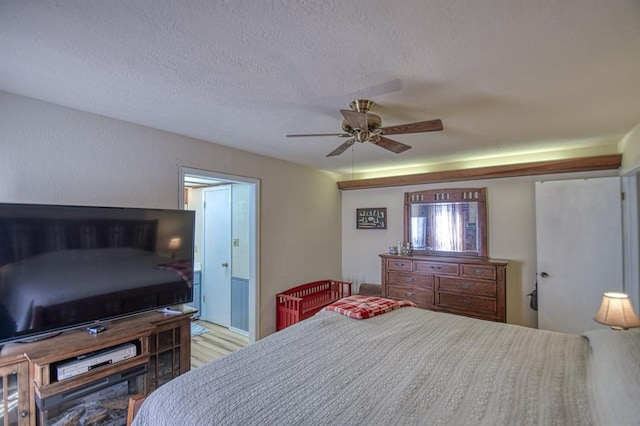 bedroom featuring a textured ceiling, ceiling fan, and light wood finished floors