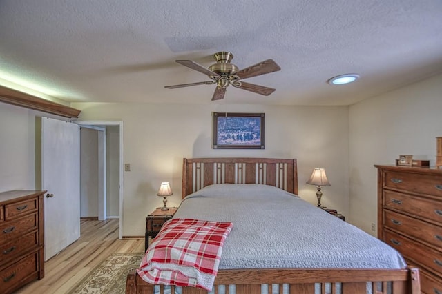 bedroom featuring baseboards, ceiling fan, a textured ceiling, light wood-type flooring, and recessed lighting