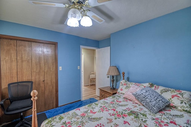 bedroom featuring a ceiling fan, a closet, and wood finished floors