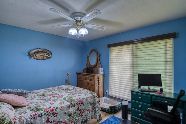 bedroom featuring ceiling fan, a textured ceiling, and wood finished floors