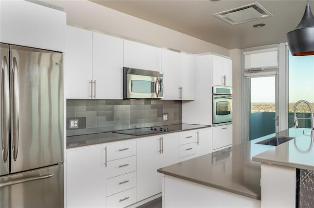 kitchen featuring white cabinetry, backsplash, and stainless steel appliances