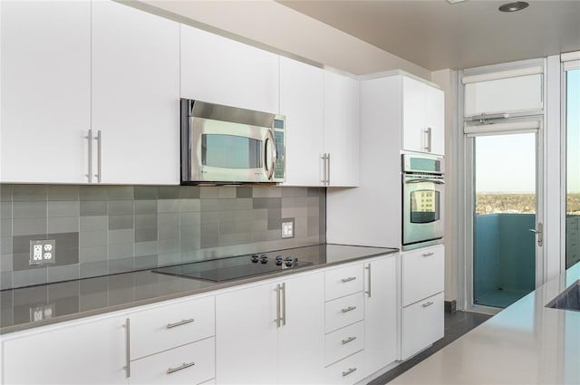 kitchen with appliances with stainless steel finishes, decorative backsplash, and white cabinets