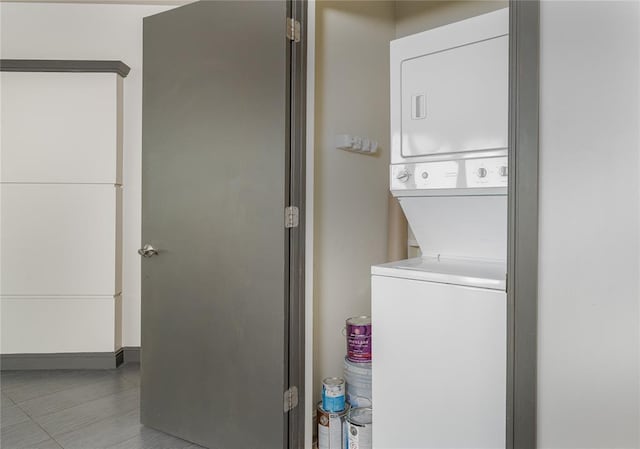 clothes washing area featuring stacked washing maching and dryer