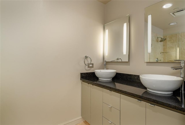 bathroom featuring tiled shower and vanity