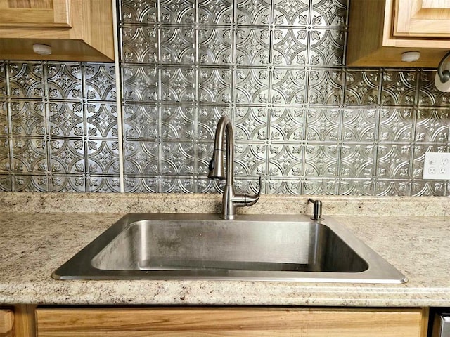 kitchen featuring light stone counters and sink