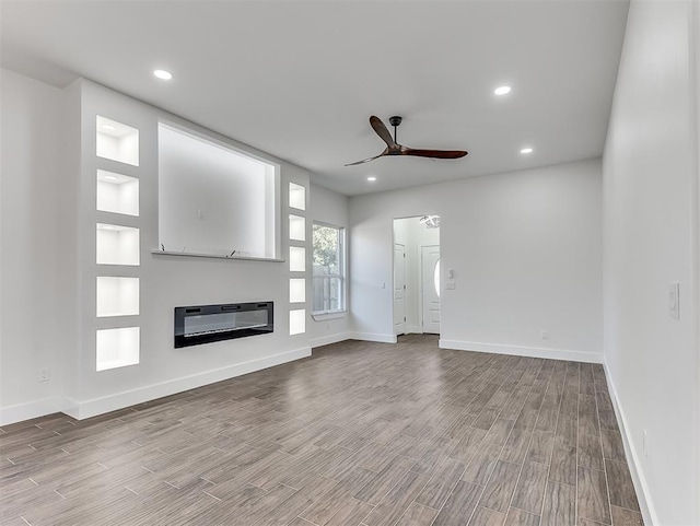 unfurnished living room with heating unit, hardwood / wood-style flooring, and ceiling fan