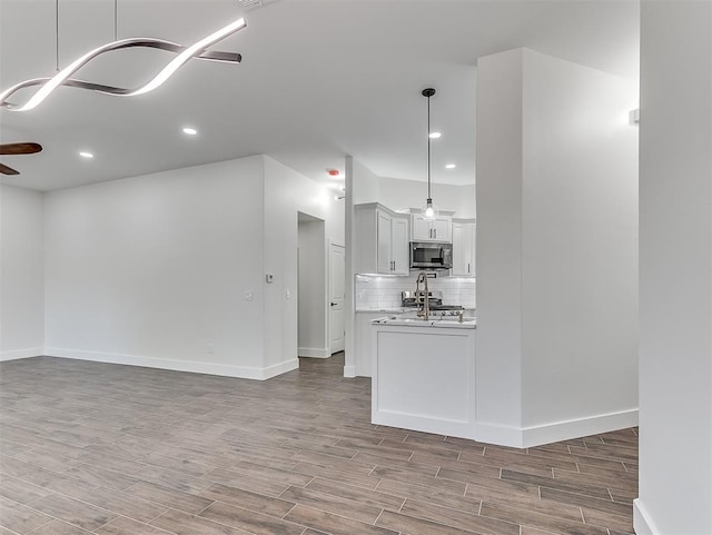 unfurnished living room with hardwood / wood-style floors and ceiling fan