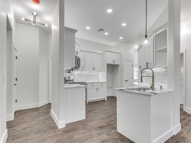 kitchen with hardwood / wood-style floors, stainless steel appliances, white cabinetry, and sink