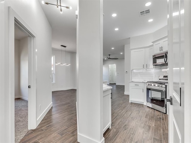 kitchen featuring white cabinetry, hardwood / wood-style floors, ceiling fan, and appliances with stainless steel finishes