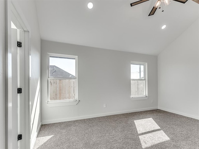 spare room featuring light carpet, ceiling fan, and vaulted ceiling